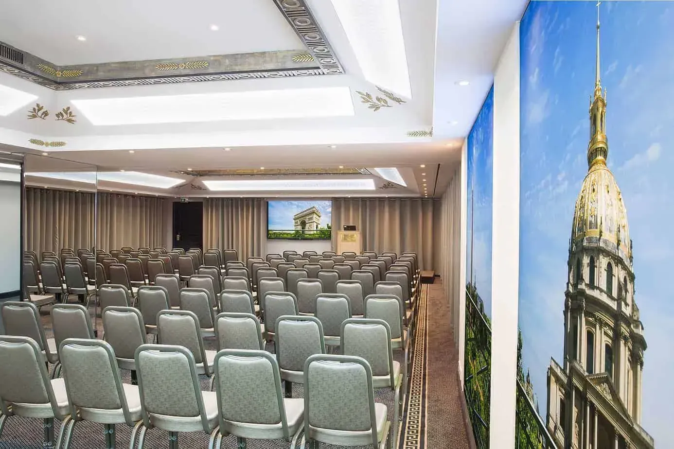 Theatre-style seating beside a large printed panel of a Paris monument