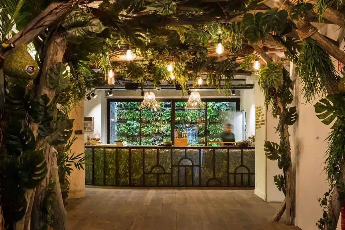 Industrial hall with exposed ducts, high ceilings and many plants