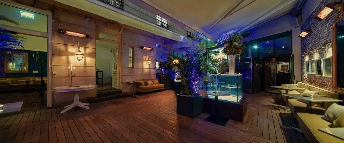 Terrace at night with plants, a fish tank and warm lighting