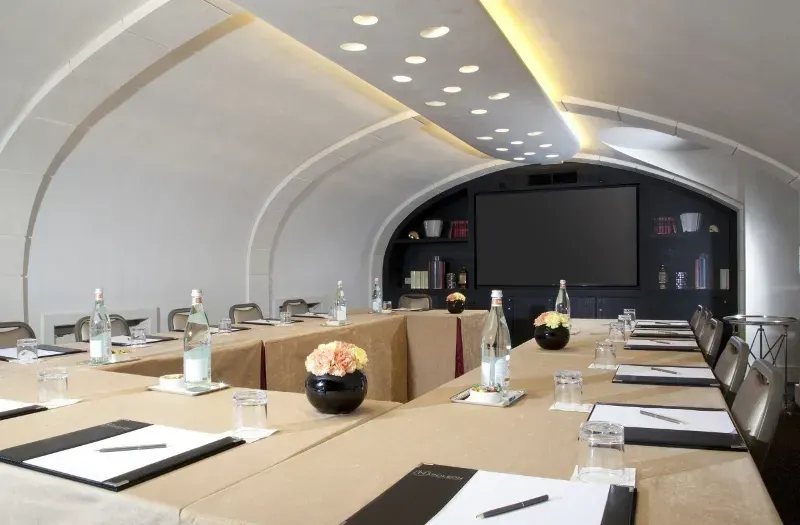 Vaulted room with a screen at one end and boardroom seating